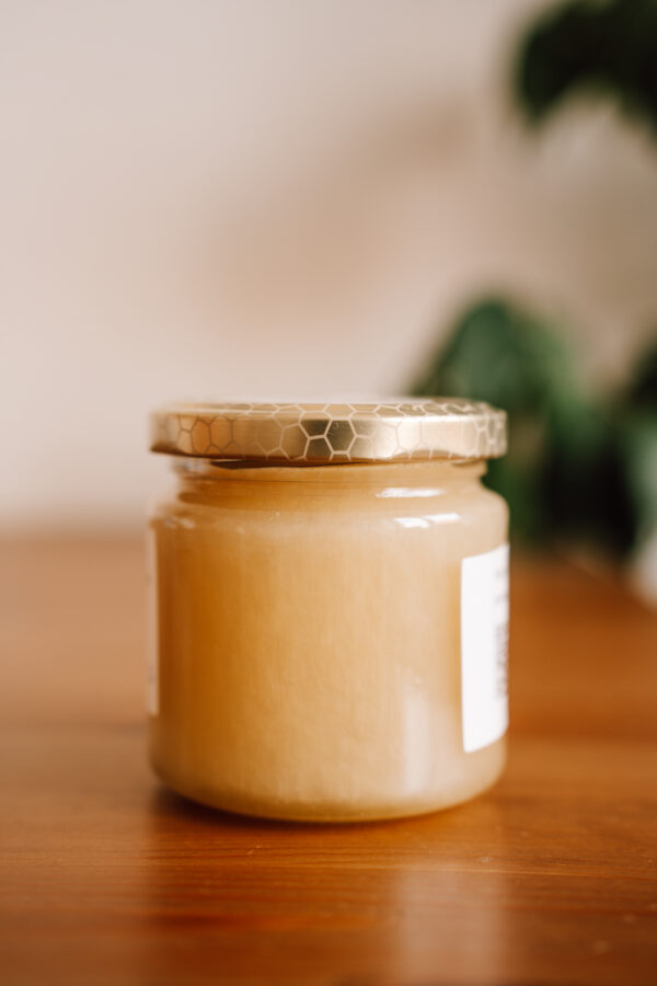 Ein Glas Honig auf einem Holztisch, Rückseite